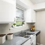 Charming kitchen with sleek granite countertops, bright white cabinets, and sunlit window view, perfect for a cozy dining experience.