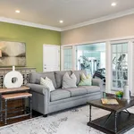 Chic living room with a cozy grey sofa, stylish decor, and modern fitness room view creating a harmonious blend of comfort and functionality.