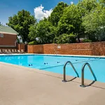 Inviting outdoor pool area surrounded by lush greenery and comfortable lounge chairs, perfect for relaxation and leisure.