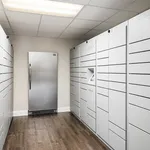 Modern package locker room with sleek metallic lockers and hardwood flooring, offering secure and convenient parcel storage in a stylish setting.