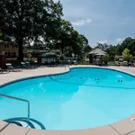 Inviting outdoor swimming pool area with greenery and sun loungers, ideal for relaxation and leisure in a serene residential setting.