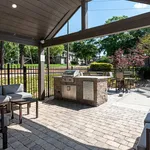Charming outdoor patio with a stylish barbecue area, comfortable seating, and lush green surroundings for perfect relaxation.
