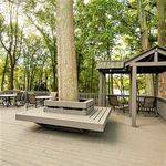 Stunning outdoor patio with modern seating, nestled among lush trees, offering serene nature views.