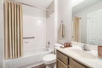 Elegant bathroom featuring a modern sink, sleek faucet, and a pristine shower area with neutral decor accents.