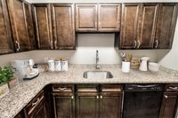 Modern kitchen with elegant wooden cabinets, sleek granite countertops, and high-end appliances, perfect for culinary enthusiasts.