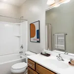 Contemporary bathroom with sleek white fixtures, modern art, and elegant lighting, ideal for a stylish apartment.