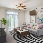 Bright and inviting living room featuring a cozy gray sofa with colorful cushions, modern artwork, and a stylish striped rug. Abundant natural light streams through large sliding glass doors with vertical blinds, complemented by a chic ceiling fan.