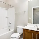 Modern bathroom featuring sleek fixtures, a cozy bathtub, and elegant wooden cabinetry perfect for relaxation.