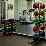 Vibrant gym space with colorful dumbbells, medicine balls, and modern exercise equipment for an energetic workout atmosphere.
