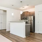 Modern kitchen featuring sleek stainless steel appliances, granite countertops, and elegant pendant lighting, all surrounded by rich wood cabinetry.