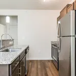 Modern kitchen with sleek granite countertops, stainless steel appliances, and elegant hardwood flooring.