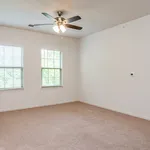 Bright, spacious room with soft carpeting, large windows, and a modern ceiling fan, ideal for a cozy bedroom.