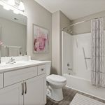 Contemporary bathroom with sleek white fixtures, elegant vanity, and stylish modern decor.