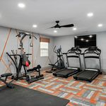 Modern gym with state-of-the-art equipment including treadmills and exercise machines, set in a stylish room with contemporary geometric design.