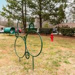 Inviting apartment complex dog park featuring agility hoops and a tunnel surrounded by lush greenery.