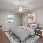 Chic bedroom with modern decor, plush bedding, and natural light from the window, creating a cozy and inviting atmosphere.