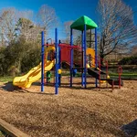 Vibrant playground with colorful slides and climbing structures nestled in a serene park setting, perfect for outdoor family fun.