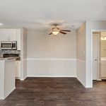 Charming open-concept kitchen and dining area with sleek flooring, modern appliances, and elegant lighting, perfect for cozy gatherings.