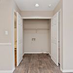 Charming laundry nook with double doors, featuring stylish wood flooring and ample shelving space.