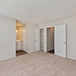 Bright, spacious bedroom with plush carpet, featuring a walk-in closet and en-suite bathroom, ideal for comfort and style.
