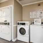 Modern laundry room with stacked dryers and washing machines, offering convenience and efficiency for residents.