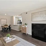 Chic open-concept living area with elegant fireplace, modern dining space, and sleek kitchen, perfect for contemporary living.