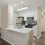 Contemporary kitchen with sleek white cabinetry, modern appliances, and a stylish breakfast bar.