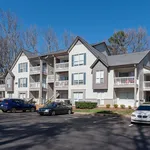 Charming multi-story apartment building with balconies and ample parking in a serene neighborhood setting.