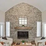 Charming living room with a rustic brick accent wall, stylish fireplace, and elegant seating for cozy living.
