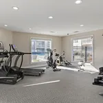 Modern fitness center with state-of-the-art equipment, bright natural lighting, and elegant design.