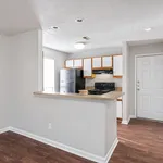 Bright and modern kitchen with sleek black appliances, cozy breakfast bar, and stylish wood flooring.