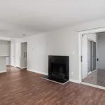 Inviting living room with elegant wood flooring, a cozy fireplace, and sliding glass doors leading to a private patio.