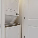 Compact laundry closet featuring a modern stackable washer and dryer set, perfect for efficient living spaces.