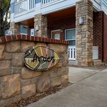 Charming apartment entrance featuring rustic stone pillars and a welcoming sign, exuding warmth and elegance.