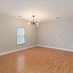 Spacious and bright living area with elegant wooden flooring and modern chandelier.