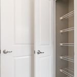 Bright double door storage closet with metal shelving, offering ample space for organization.