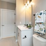 Chic and modern bathroom with elegant lighting, sleek vanity, and stylish floral accents creating a refreshing ambiance.