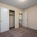Bright bedroom with plush carpeting and spacious closet in modern apartment.