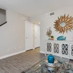 Inviting living space with stylish decor, showcasing a beautiful sunburst mirror and rustic white console table, complemented by chic wooden flooring.