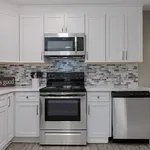 Modern kitchen with sleek stainless steel appliances, elegant white cabinetry, and stylish mosaic backsplash.