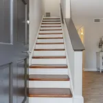Inviting staircase with elegant wood steps leading to a bright upper floor in a modern home entrance.