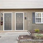 Charming apartment entrance with twin black doors, elegant lighting, and inviting window shutters, perfect for cozy urban living.