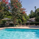 Charming outdoor pool area surrounded by lush greenery and comfortable lounge chairs, perfect for relaxation.