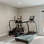 Modern home gym with state-of-the-art treadmill and elliptical machine in a bright, inviting space.