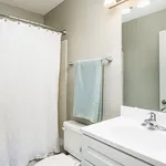 Bright and modern bathroom with elegant fixtures, featuring a chic vanity, soft lighting, and a tasteful shower curtain.