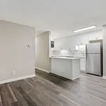 Modern kitchen design with sleek white cabinets, stainless steel appliances, and elegant hardwood flooring creating a spacious and inviting atmosphere.