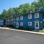Charming townhouse community with vibrant blue exteriors, inviting walkways, and lush green surroundings.