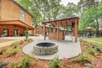 Inviting outdoor community space featuring a cozy fire pit, modern seating area, and lush landscaping, perfect for relaxation and social gatherings.