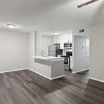 Modern open-concept kitchen with stainless steel appliances and sleek hardwood flooring, perfect for contemporary living.