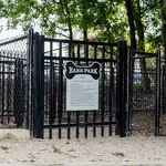 Inviting pet playground featuring a fenced Bark Park with lush greenery, ideal for pet-friendly apartment living.